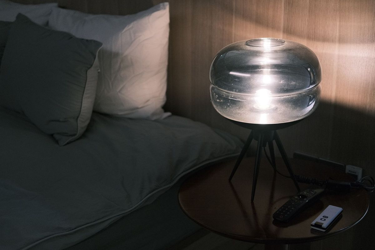 A cozy bedroom with a table lamp glowing at night