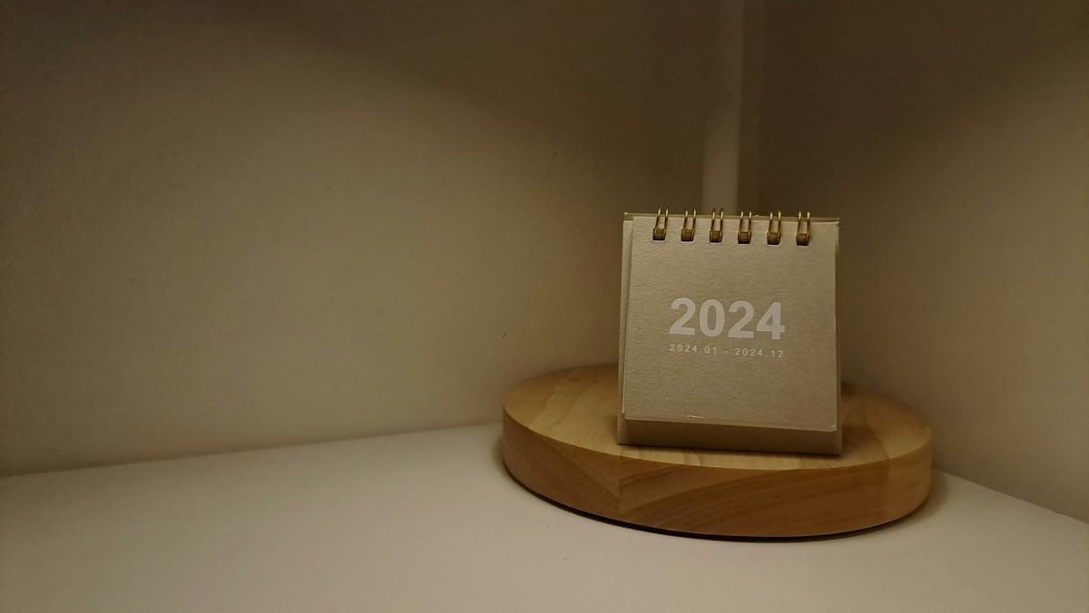A desk calendar and lamp on a wooden desk