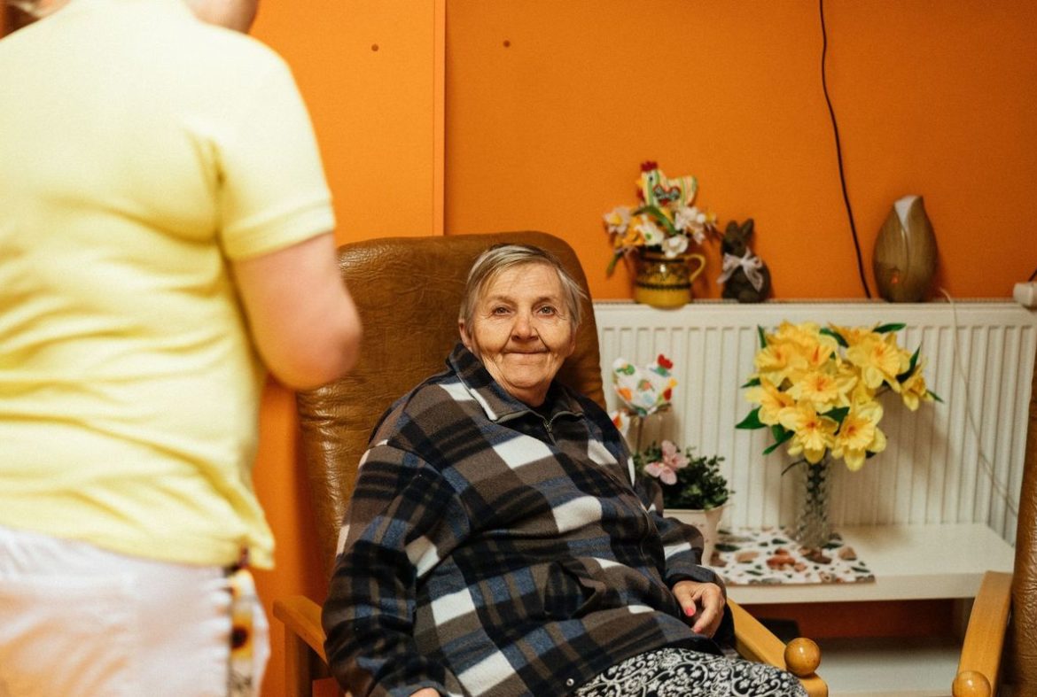 An older woman sitting in an armchair at home