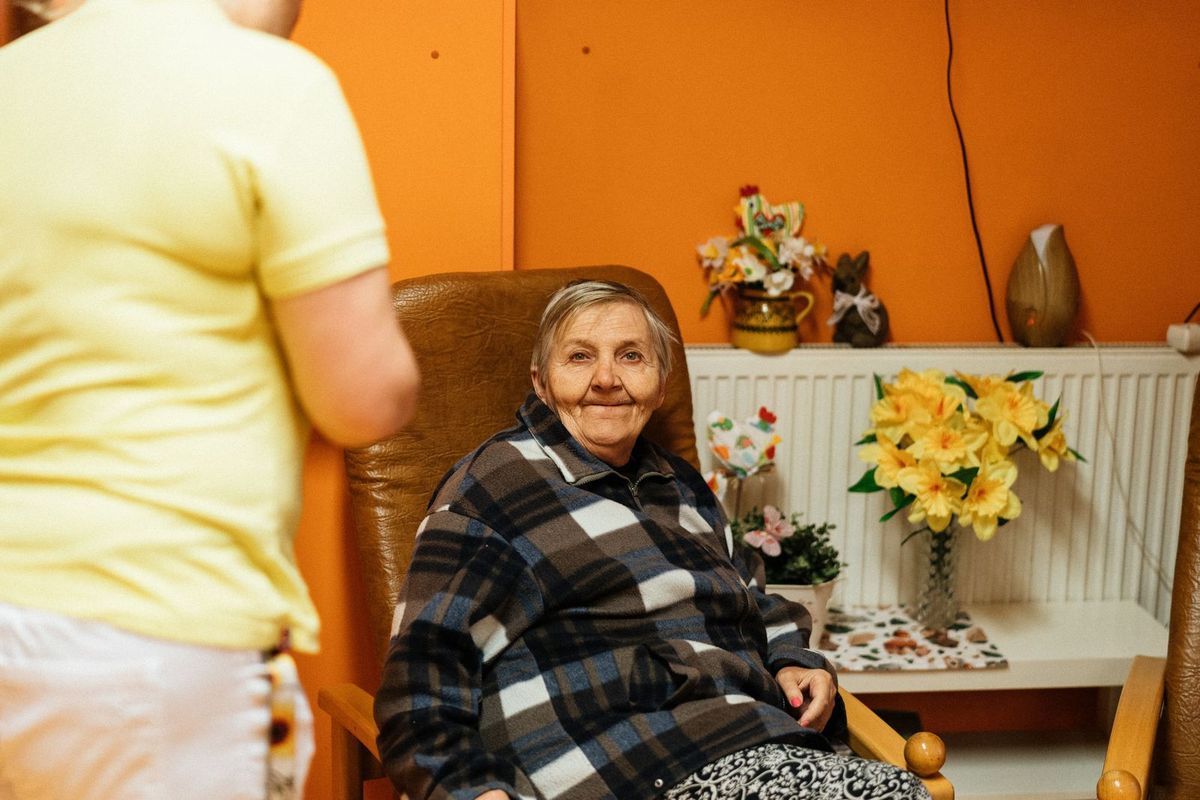 An older woman sitting in an armchair at home