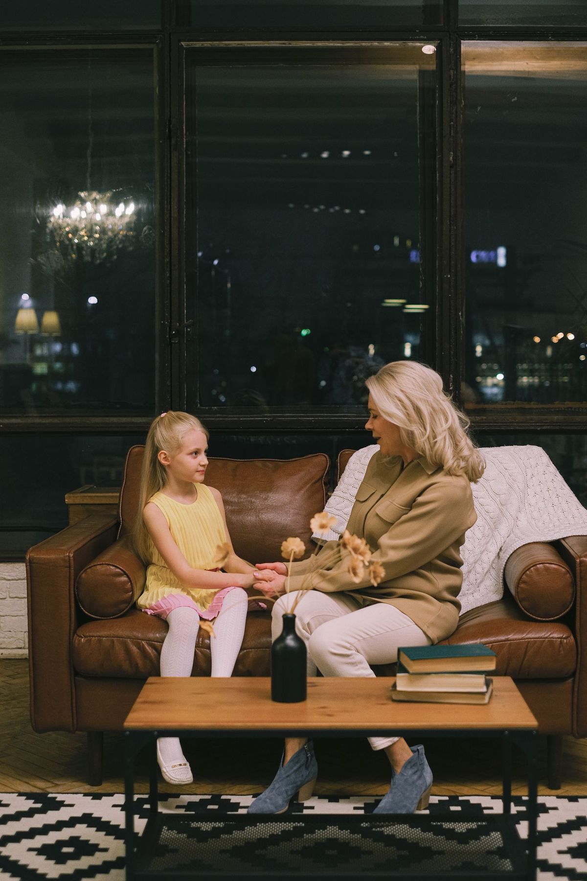 An older woman and a younger woman talking together on a sofa