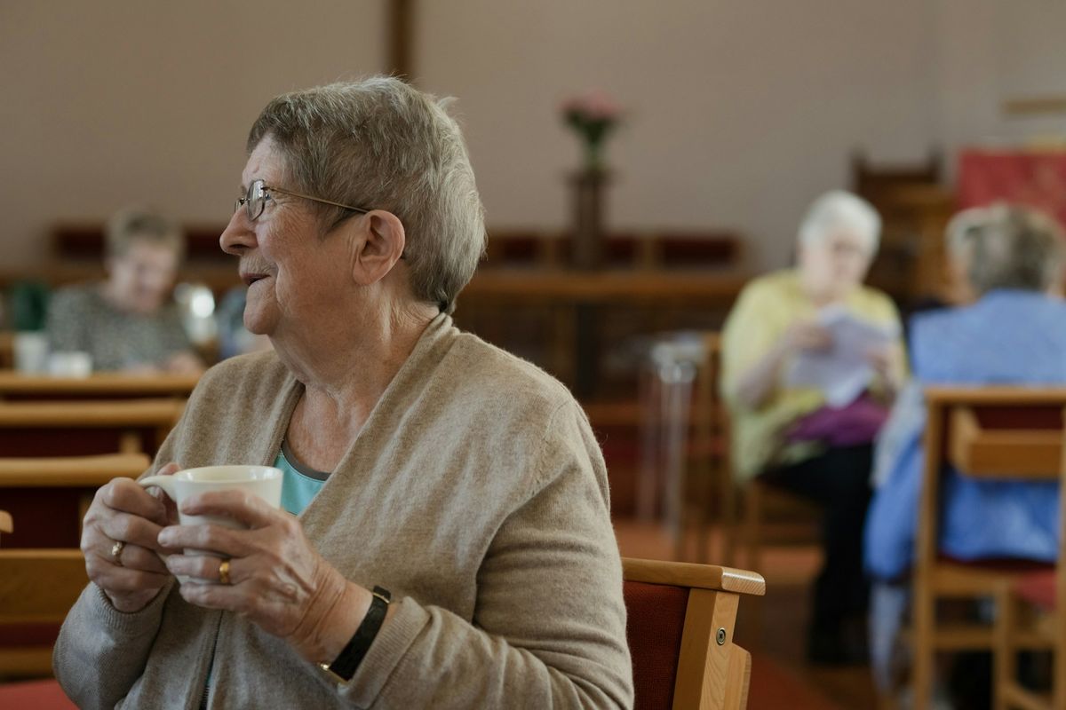 Older women sitting around a table with cups of tea