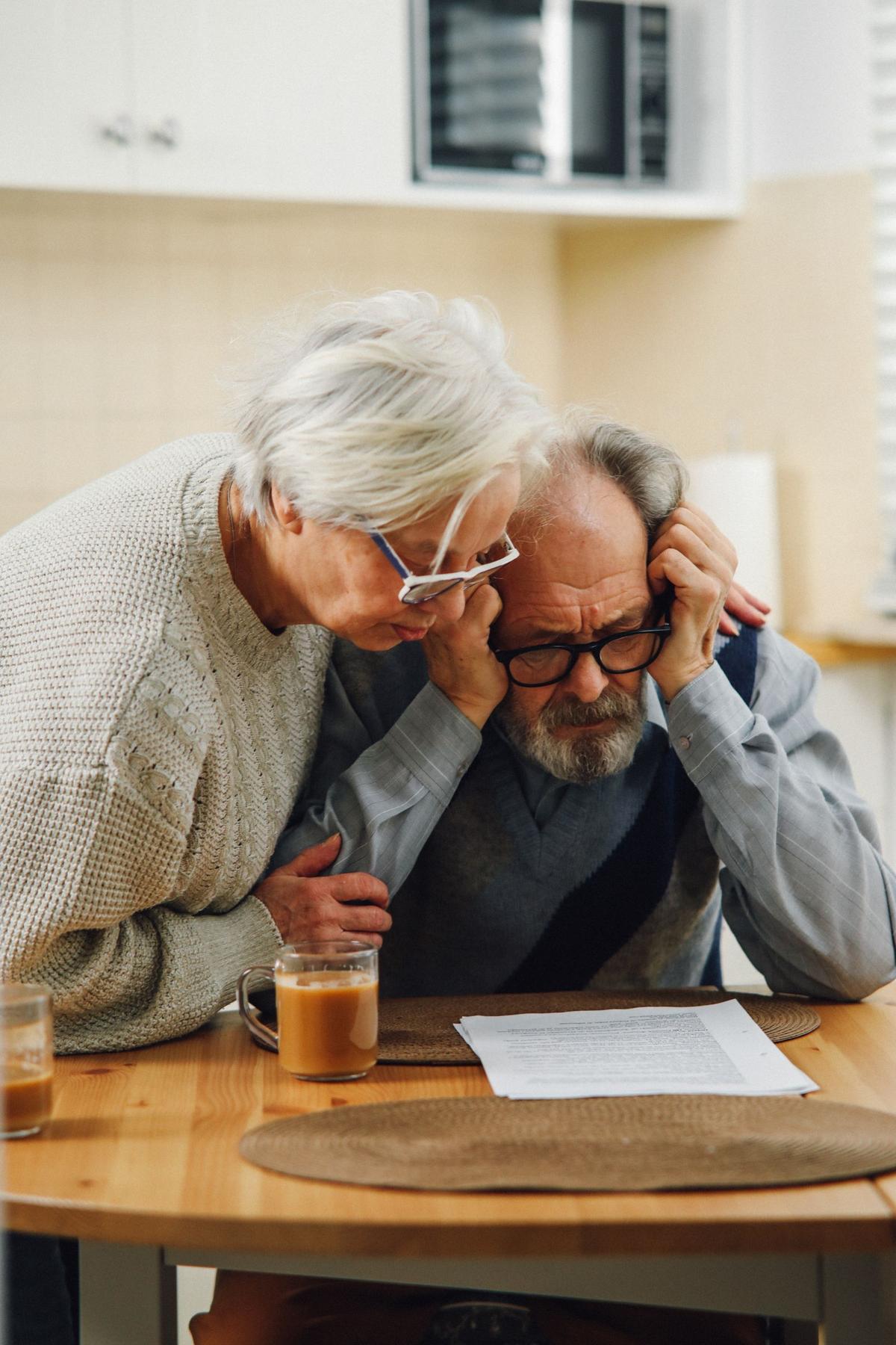 An older couple looking at documents together at a table